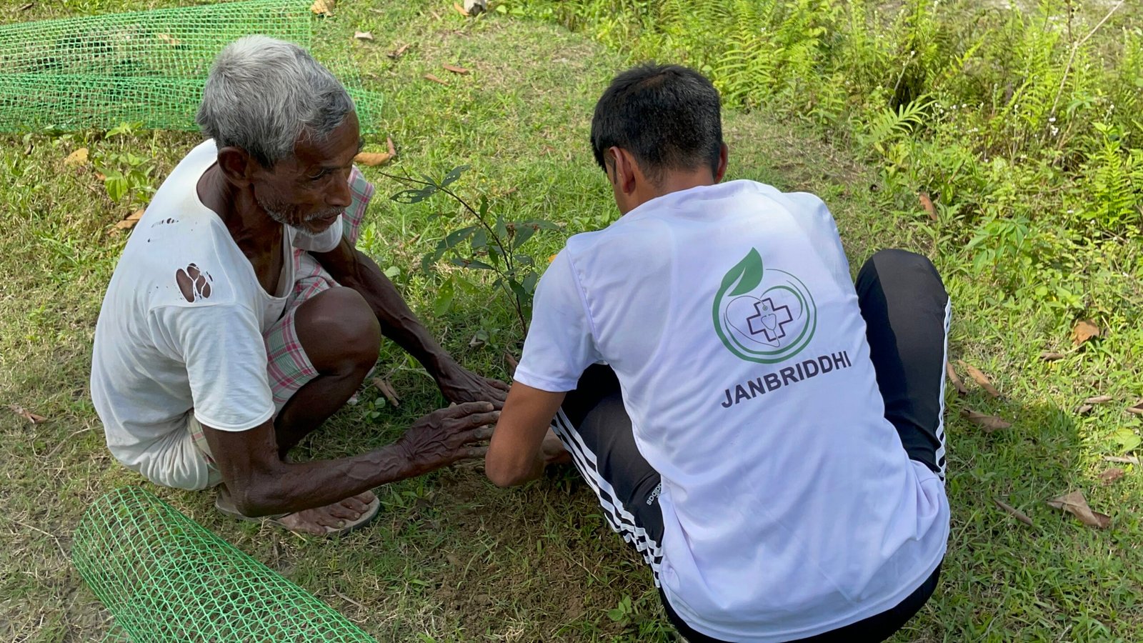 Volunteer planting a sapling during a tree plantation drive in Bajali