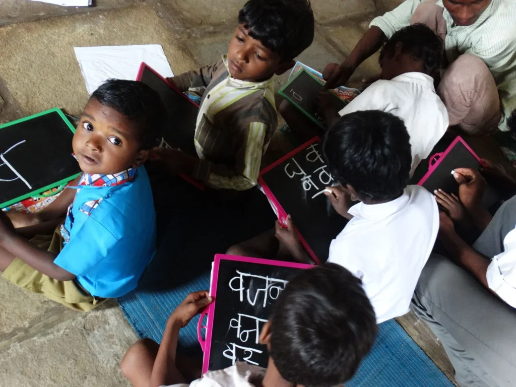 Children writing on slates in a village school