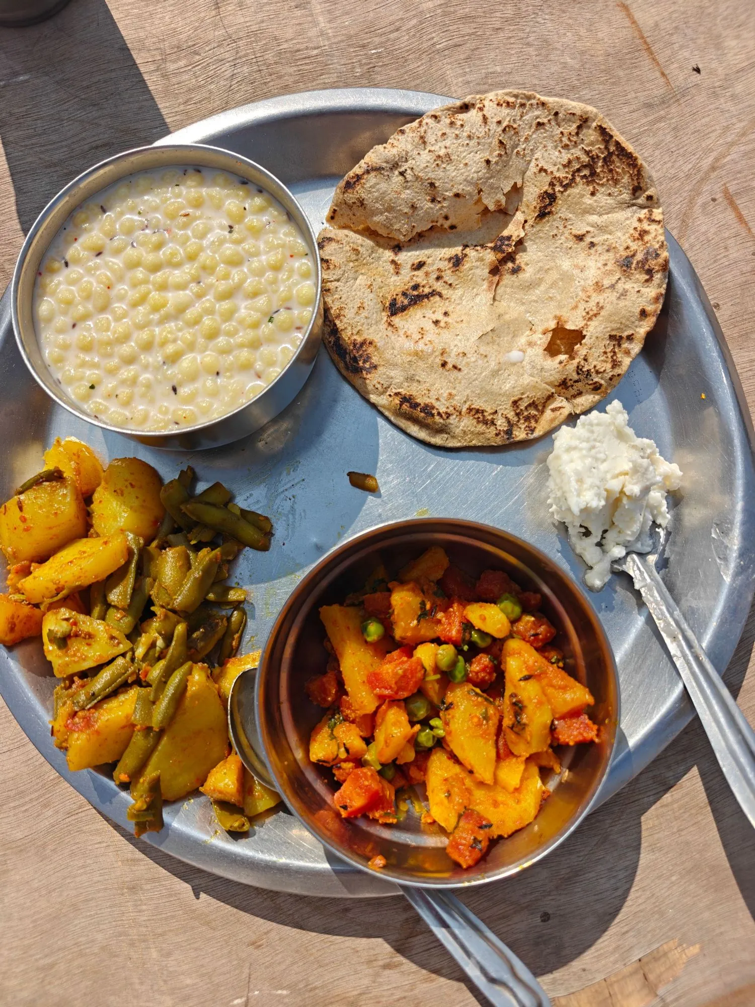 A plate with roti, vegetables and dal